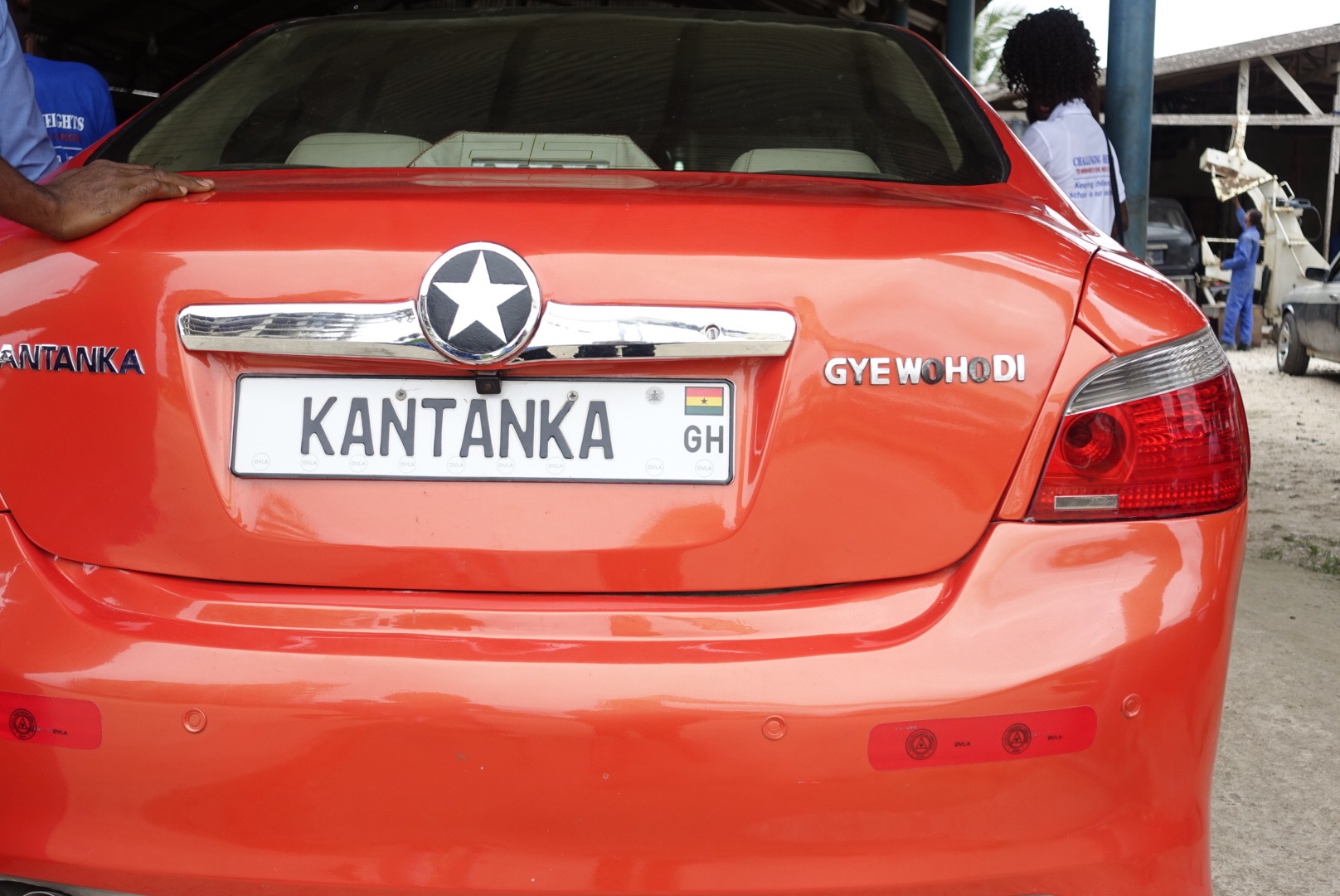 the back of a red sedan style car, the kantanka gyewohodi